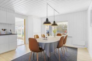 a kitchen and dining room with a table and chairs at BL1680-Blokhus-Klitgaardsvej-18 in Blokhus