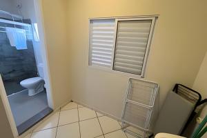 a bathroom with a toilet and a window at Studio kitnet Apartamento Privativo Jundiai 08 in Ermida