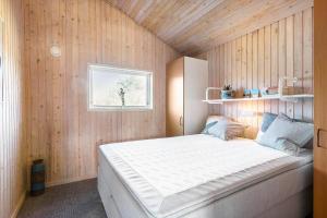a bedroom with a large white bed in a wooden wall at BL1462-Saltum-Revlingevej-32 in Saltum