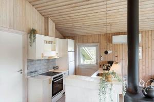 a kitchen with white cabinets and a wooden ceiling at BL1462-Saltum-Revlingevej-32 in Saltum +13 photos