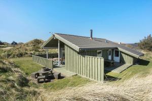 a small green house with a deck in a field at BL1462-Saltum-Revlingevej-32 in Saltum