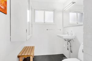 a white bathroom with a toilet and a sink at BL1612-Blokhus-Jens-Baerentsvej-3 in Blokhus +16 photos