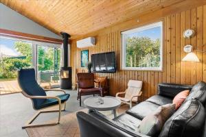 a living room with a couch and chairs and a tv at BL1728-Blokhus-Kaeruldvej-7 in Blokhus