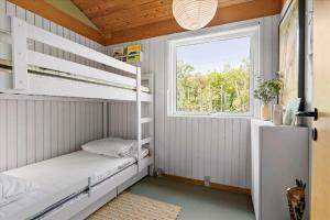 a bedroom with bunk beds and a window at BL1728-Blokhus-Kaeruldvej-7 in Blokhus