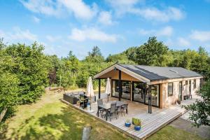 a cabin with a deck with a table and chairs at BL1728-Blokhus-Kaeruldvej-7 in Blokhus