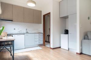 a kitchen with white cabinets and a table in a room at Memórias in Nogueira da Regedoura