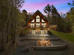 a house with a fire pit in front of it at Luxury Log Cabin Lakefront, Game room & Fire Pit, in Schenevus