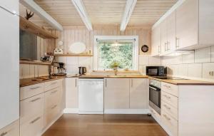 a kitchen with white cabinets and a window at Three-Bedroom Holiday Home In Hovborg in Hovborg