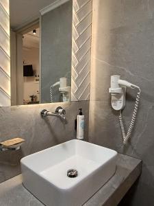 a white sink in a bathroom with a mirror at Bacchus Winter Studios in Archea Pissa