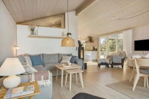 a living room with a blue couch and a table at BL1458-Blokhus-Lyngmarken-6 in Blokhus