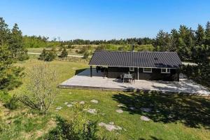 une maison avec une table de pique-nique devant elle dans l'établissement BL1272-Pandrup-Kirkekrogen-7, à Pandrup