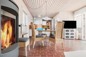 a living room with a fireplace and a table with chairs at BL1397-Pandrup-Rodhus-Klitvej-363 in Pandrup