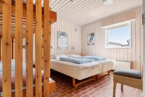 a bedroom with two bunk beds and a window at BL1397-Pandrup-Rodhus-Klitvej-363 in Pandrup