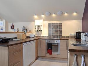 una cocina con estufa horno superior al lado de un fregadero en The Bait Shed, en Filey