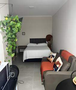 a living room with a bed and a couch and a tv at Studio kitnet Apartamento Privativo Jundiai 03 in Jundiaí
