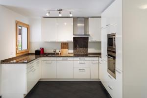 a white kitchen with white cabinets and appliances at Anatas in Saas-Fee