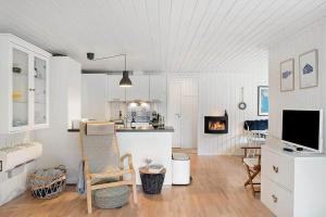 una cucina e un soggiorno con camino e TV di BL1274-Blokhus-Raappenmark-30 a Blokhus