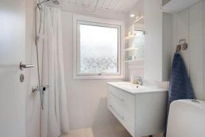 un bagno bianco con un lavandino e una finestra di BL1274-Blokhus-Raappenmark-30 a Blokhus Altre 16 foto