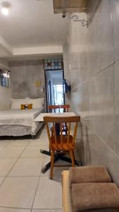 a room with a chair and a table and two beds at Praia de Pajuçara - Kitnet 02 - Castelo da Lolla in Maceió