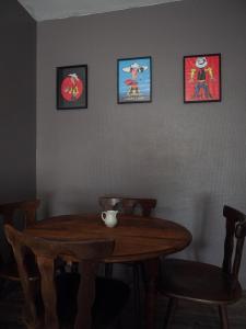 a wooden table in a room with four pictures on the wall at Appartement rénové sur le thème du Far West in Soyaux +3 photos
