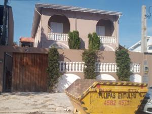 a house with a yellow dumpster in front of it at Studio kitnet apartamento Privativo Jundiai 12 in Jundiaí