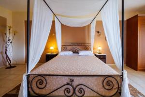 1 dormitorio con 1 cama con dosel y 2 mesitas de noche en Hotel Epavlis, en Káto Poróïa