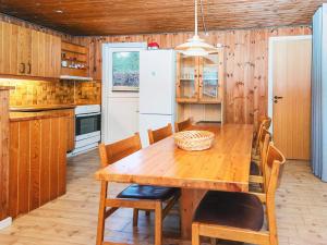 a kitchen with a wooden table and a white refrigerator at 6 person holiday home in Fårvang in Fårvang +15 photos