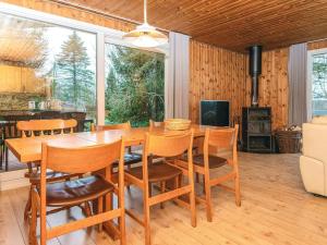 a dining room with a wooden table and chairs at 6 person holiday home in Fårvang in Fårvang