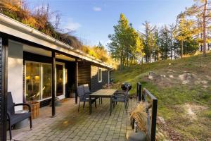 a patio with a table and chairs on a house at BL946-Blokhus-Graevlingevej-8 in Blokhus