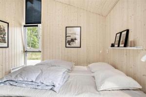 un letto bianco in una camera con due cuscini di BL377-Blokhus-Maxvej-9 a Blokhus