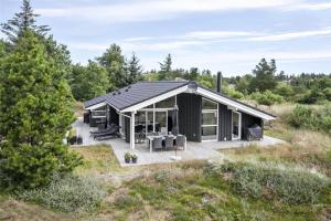 una casa nera in mezzo a un campo di BL377-Blokhus-Maxvej-9 a Blokhus