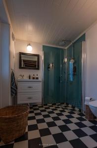 a bathroom with a shower and a checkered floor at Cozy older house in scenic surroundings in Stord