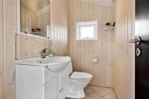 a bathroom with a white sink and a toilet at BL819-Blokhus-Pirupshvarrekrogen-2 in Blokhus