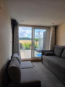 The Pod Quiet Sun Patio Fab Steam &Countryside Views في ويبورن: غرفة معيشة مع أريكة ونافذة كبيرة
