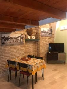 a dining room with a table with chairs and a tv at La casetta in Serracapriola