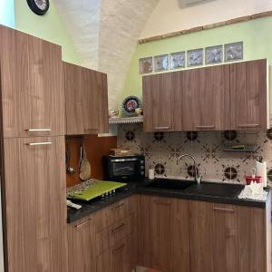 a kitchen with wooden cabinets and a microwave at La casetta in Serracapriola
