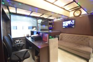 a office with a desk and a couch and a clock at Hotel Arma Court - Near US Embassy, BKC in Mumbai
