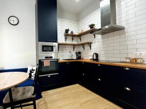 a kitchen with a table and a clock on the wall at Современная и уютная квартира в районе ЭКСПО, ТРЦ Mega Silk Way in Astana