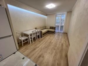 a living room with a couch and a table and chairs at Green HOUSE апартаменти вул Зелена 204 новобуд in Lviv