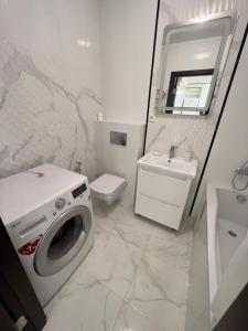 a bathroom with a washing machine and a sink at Green HOUSE апартаменти вул Зелена 204 новобуд in Lviv