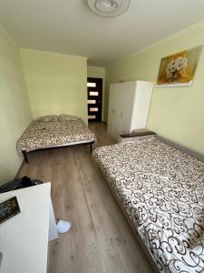 two beds in a room with wooden floors at Green HOUSE апартаменти вул Зелена 204 новобуд in Lviv