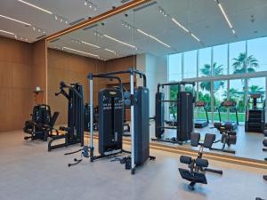 a gym with a lot of treadmills and exercise equipment at Beach Please in Dubai