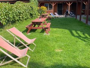 a picnic table and chairs sitting in the grass at Domki na wynajem w Kątach Rybackich in Kąty Rybackie +1 photo