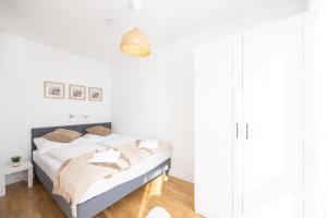 a white bedroom with a bed with white walls at Deluxe Apartment with garden! Near SCS & Industry Center NÖ in Wiener Neudorf