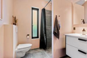 a bathroom with a toilet and a sink and a shower at BL1433-Blokhus-Mollevej-11 in Blokhus +26 photos