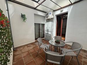 フリヒリアナにあるTwo Bedroom one bathroom with communal swimming poolのバルコニーにテーブルと椅子が置かれたパティオ