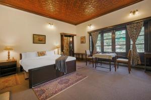 a bedroom with a bed and a table and chairs at SaffronStays Awakening -Family Suite in Srinagar +31 photos
