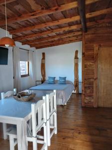 a bedroom with two beds and a table and chairs at La Cabaña de Sofi in Tandil