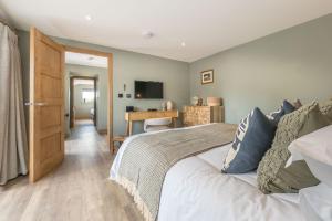 Un dormitorio con una cama, un escritorio y un televisor. en Ysgubor-Cerbyd, en Amroth