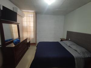 a bedroom with a bed and a dresser and a mirror at Apartamento Aeropuerto Maiquetia en Planta Baja in Catia La Mar